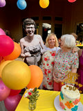Life-size die-cut photo cutout of a young man standing with guests at a 90th birthday party